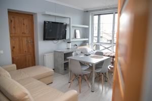 a living room with a table and chairs and a television at Hostel Gidle in Gidle
