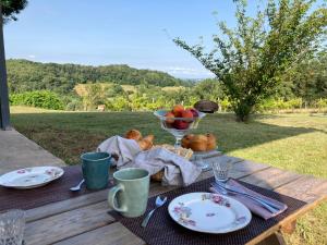 a picnic table with a bowl of fruit and a bowl of apples at Domaine Labouroume in Salies-de-Béarn
