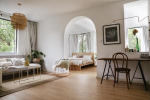 una camera da letto con un letto, un tavolo e una scrivania di Bujuexiao Inn Yuki House Luda Rd a Shanghai
