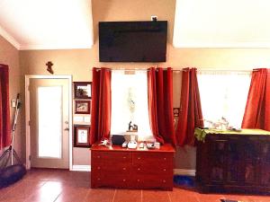a living room with red curtains and a wooden dresser at Captains Cabin on Lake in Jacksboro