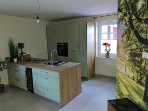 a kitchen with a sink and a counter top at Landblick 1 - Luxusferienwohnung für 4 Personen in Norddeich
