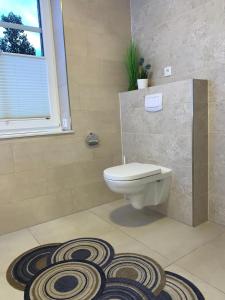 a bathroom with a toilet and a rug at Landblick 1 - Luxusferienwohnung für 4 Personen in Norddeich