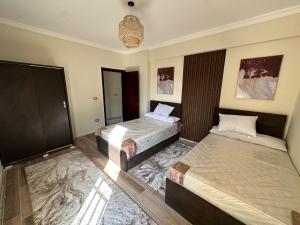 ein Schlafzimmer mit zwei Betten und einem Spiegel in der Unterkunft madinaty in Madinaty