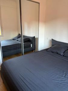 espejo en un dormitorio con cama y sofá en Appartement T3 Square Bir-Hakeim, en Perpiñán