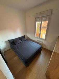 Un dormitorio pequeño con una cama y una ventana. en Appartement T3 Square Bir-Hakeim, en Perpiñán