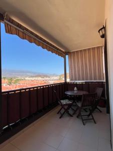 Un balcón con mesa y sillas y una gran ventana. en Mar&Relax, en Costa del Silencio