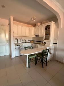 Una cocina con gabinetes blancos y una mesa y sillas. en Mar&Relax, en Costa del Silencio