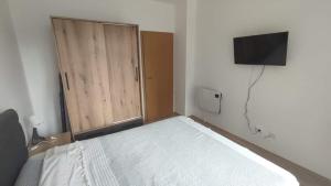 a bedroom with a bed with a closet and a television at Sun Stream Apartment in Pamporovo +29 photos