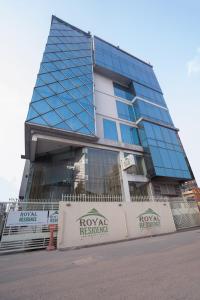 a tall building with a sign in front of it at Royal Residence Dhaka in Dhaka