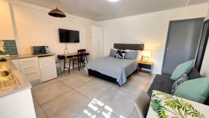 a bedroom with a bed and a kitchen with a table at Lagoon Lodge in Cape Town