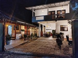 a house with a cow standing in the middle of a courtyard at Little Villa Guest House in Ahangama