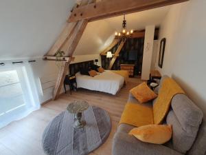 a living room with a couch and a bed at Au Domaine du Bois Joubert in Luzillé