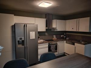 a kitchen with white cabinets and a stainless steel refrigerator at LA SUITE 159 in Namur