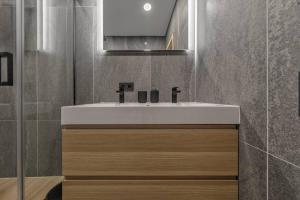 Un baño con un lavabo blanco y un espejo. en Svencelės burė 10, en Svencelė