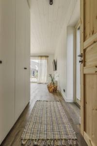 un pasillo con una puerta y una alfombra en el suelo en Svencelės burė 10, en Svencelė