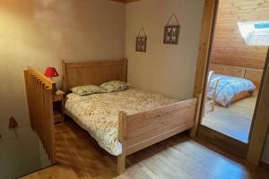 a small bedroom with a bed and a mirror at Beautiful T2 near the slopes in Saint-Chaffrey