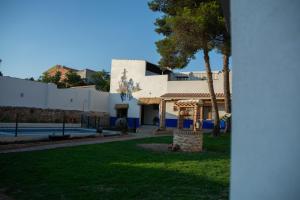 un edificio blanco con una palmera en un patio en Casa Rural La Moreneta, en Las Mesas