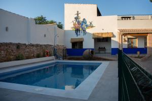 a house with a swimming pool in front of a building at Casa Rural La Moreneta in Las Mesas