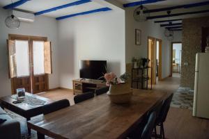 a living room with a large wooden table and a couch at Casa Rural La Moreneta in Las Mesas