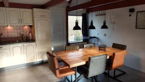 a kitchen with a wooden table and chairs at Vakantiehuis Toermalijn in Simpelveld