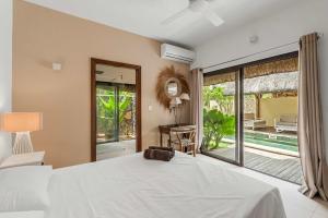 une chambre avec un lit et une grande fenêtre dans l'établissement Villa Nayla - Ocean retreat by Sealodge, à Rivière Noire
