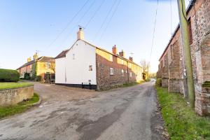 une rue vide dans un village avec des bâtiments dans l'établissement Worstead Cottage by Big Skies Cottages, à Worstead