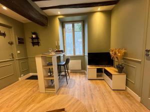 a living room with a desk and a television at La Réserve du Château in Maintenon