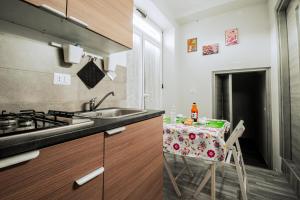 a kitchen with a sink and a table with a chair at Free Parking - Da Raf in Marano di Napoli