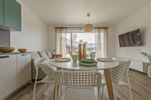 a kitchen and dining room with a table and chairs at Svencelės burė 11 in Svencelė