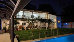 a large house with a pool in front of it at Maison des Sables - Turquoise in Port Louis