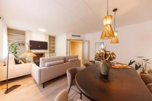 a living room with a table and a couch at Bravissimo Maragall, very spacious and central in Girona