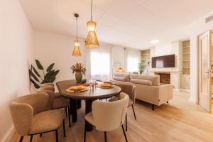 a dining room and living room with a table and chairs at Bravissimo Maragall, very spacious and central in Girona