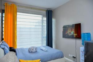 a bedroom with a window and a bed with towels at Mex Homes Studio in Nairobi +15 photos