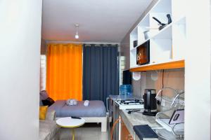 a small kitchen with a couch and a bed in a room at Mex Homes Studio in Nairobi