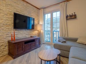 a living room with a couch and a tv on a brick wall at Oso Polar in Sierra Nevada