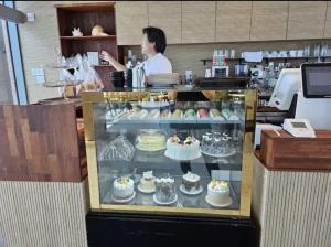 a woman standing behind a display case of cakes at Flat nearby Heaundae beach in Busan +10 photos