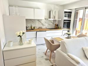 una cucina con armadi bianchi e un tavolo con fiori di Superbe Appartement Luxueux Spacieux 50 m2 Port Nice a Nizza