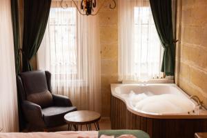 a bathroom with a chair and a tub in a room at Elite Rose Cappadocia in Uçhisar +146 photos