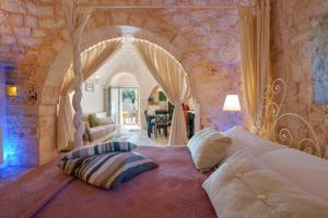a bedroom with a large bed with pillows on it at Masseria Rosa Trulli Relais in Alberobello +110 photos