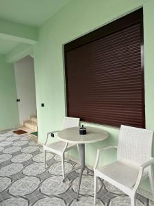 two chairs and a table in a room at Villa IBRAHIMI in Durrës