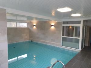 a large swimming pool with a blue tiled floor at Cuxhaven Sahlenburg in Cuxhaven
