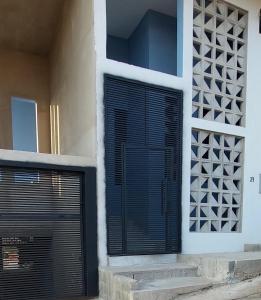 a building with a black door and a window at Loft espaçoso e confortável in Três Marias