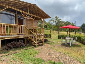 a house with a table and a red umbrella at Cabaña La Esperanza in San Bernardo