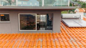 an orange roof on a house with a window at Atlantic View Residence in Funchal +47 photos