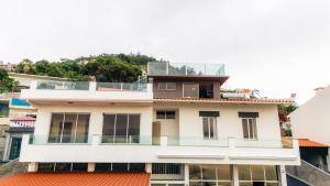 a white building with an orange roof at Atlantic View Residence in Funchal