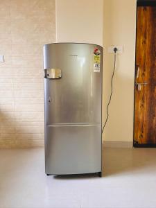 a stainless steel refrigerator sitting in a room at Owls Retreat 2BHK Modern AC Flat in Wakad Pune in Méribel Village