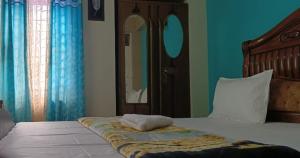 a bedroom with a bed with blue walls and a mirror at Goodluck Homestay in Guwahati