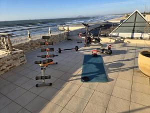 a group of exercise equipment on a patio near the beach at Lagoon Shoreline Penthouse in Cape Town