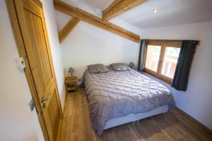 a small bedroom with a bed and a window at Vielyterra - Chalet haut de gamme - Domaine du mont blanc in Saint-Gervais-les-Bains