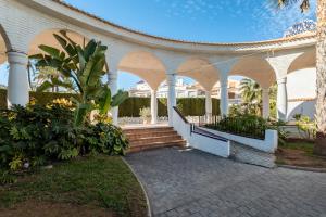 un padiglione con archi e una scala in un edificio di Casa en la playa con piscinas costa a Santa Pola